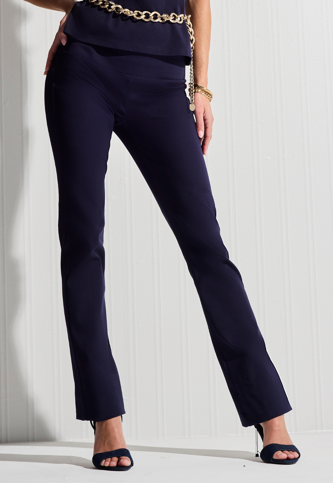 Navy blue pants worn by a person on a white background