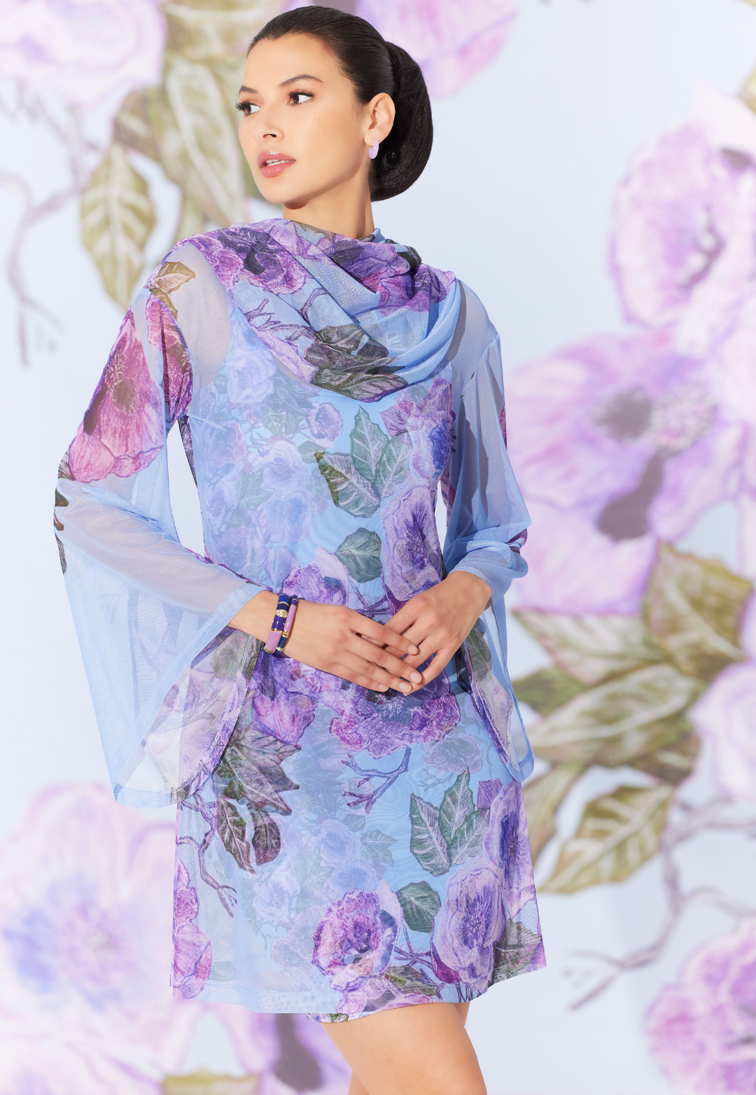 Woman wearing sheer hoodie topper over a matching mini dress in a purple floral print by designer Ala von Auersperg for womens luxury travel clothing