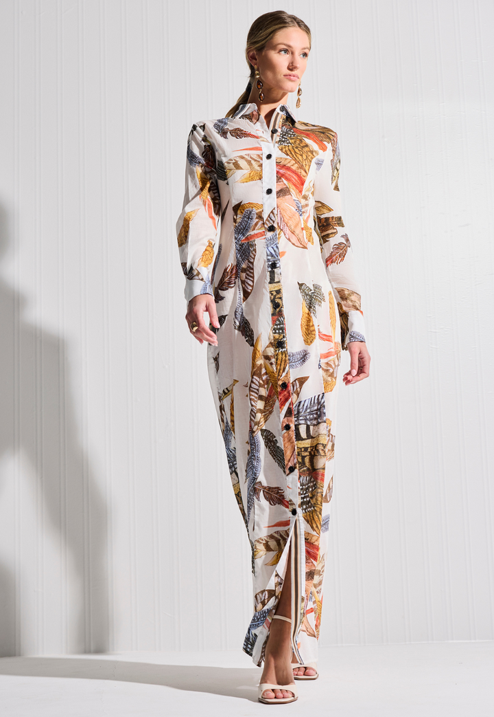 Woman wearing a long, patterned dress against a white background