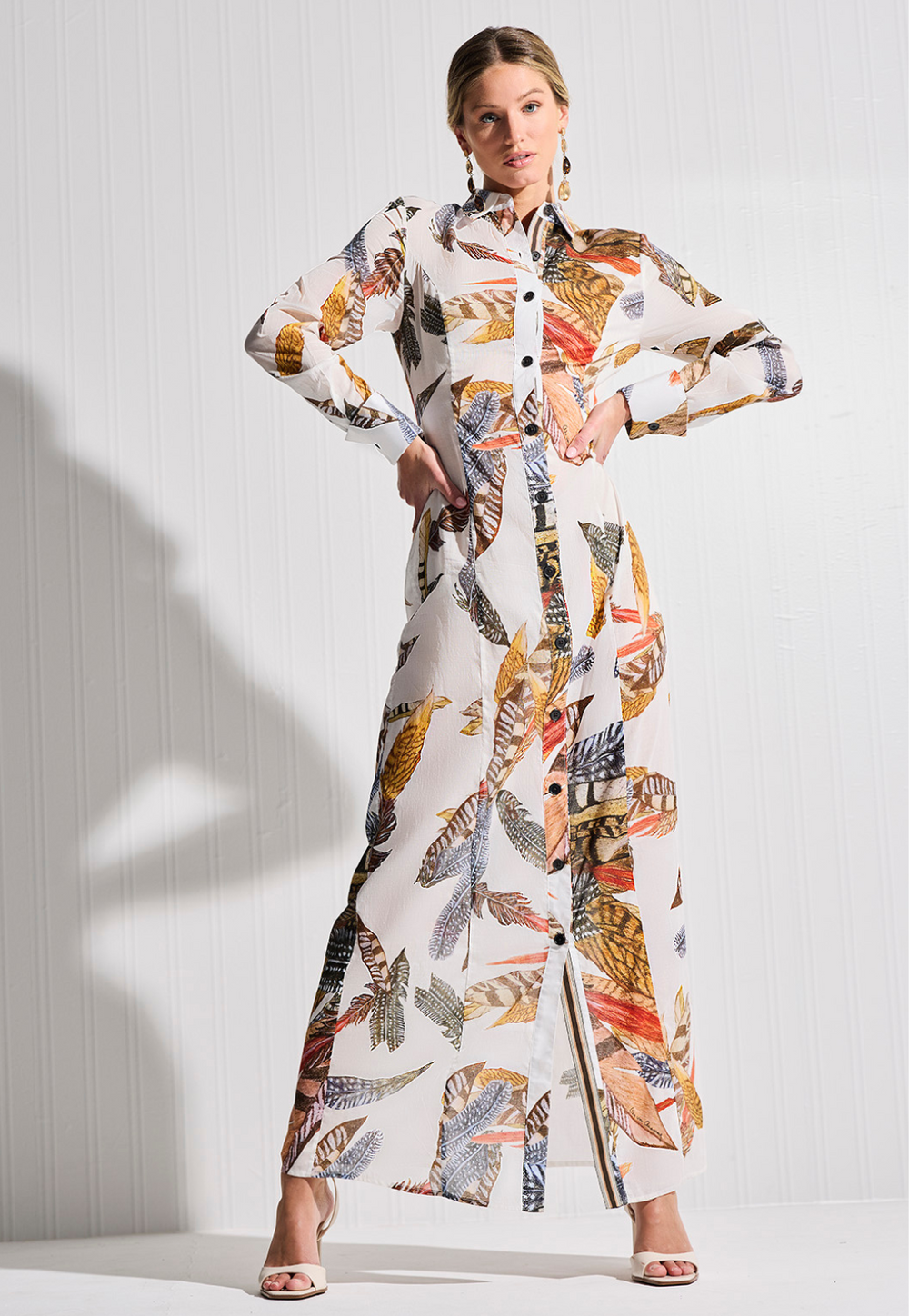 Woman wearing a colorful patterned outfit against a white background