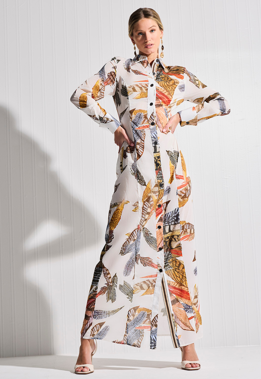 Woman wearing a colorful patterned outfit against a white background