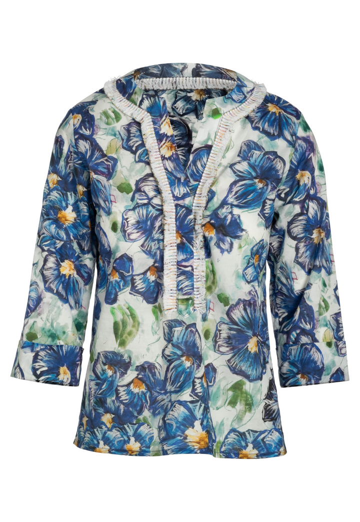 Flat image of a cotton tunic with a fringe trim in a blue floral print by designer Ala von Auersperg for womens luxury travel clothing