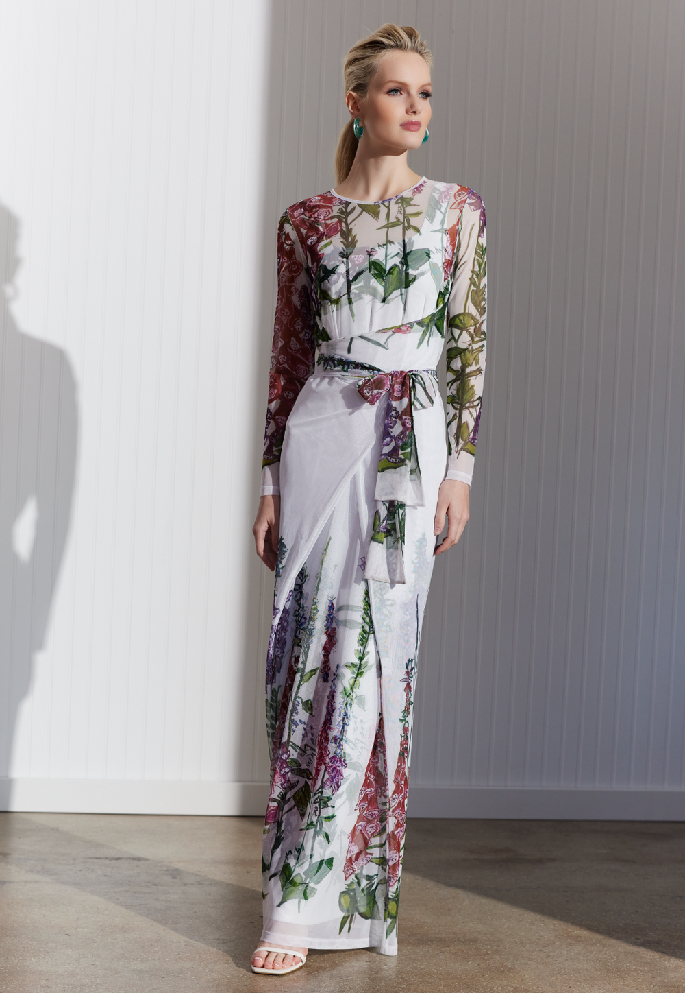 Woman wearing sheer mesh wrap dress over a long stretch knit dress both in a matching white floral print by designer Ala von Auersperg for womens luxury travel clothing