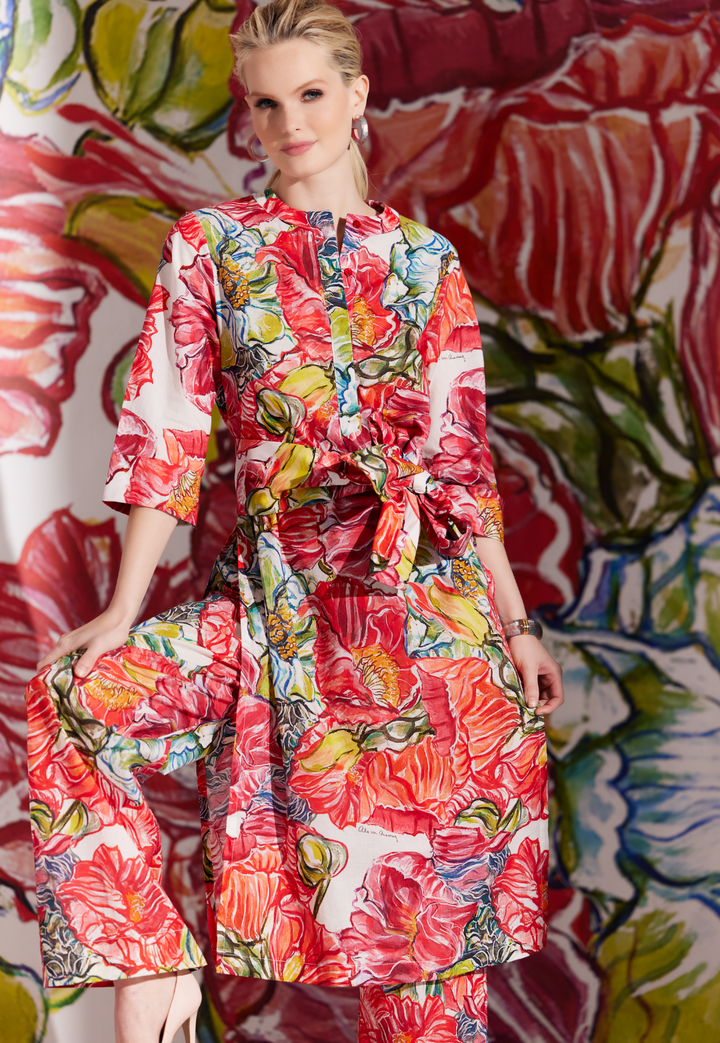 Woman wearing long red cotton tunic with matching pant and sash in a red floral print by designer Ala von Auersperg for womens luxury travel clothing
