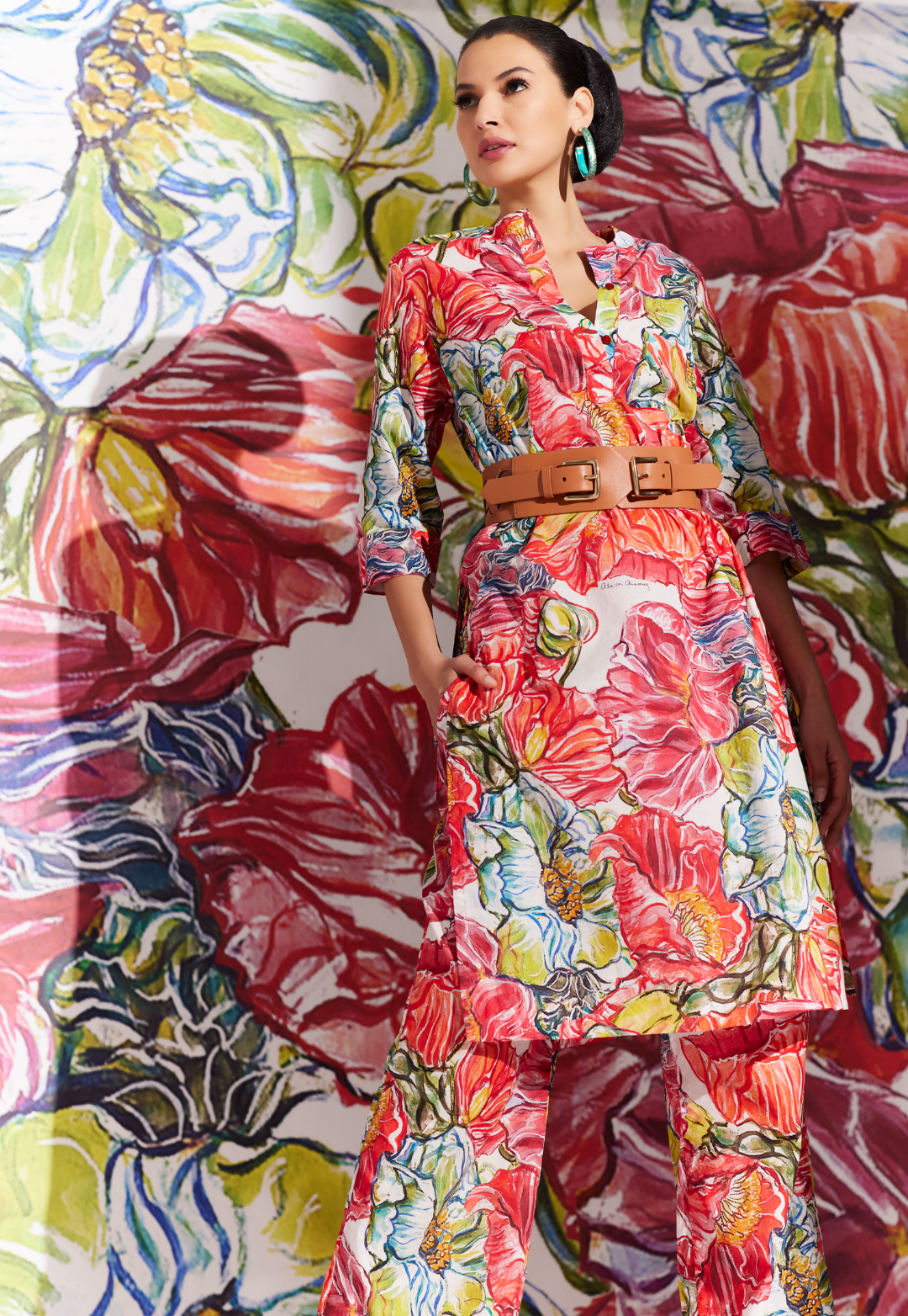 Woman wearing cotton tunic and cotton pants in a matching red floral print with leather belt by designer Ala von Auersperg for womens luxury travel clothing