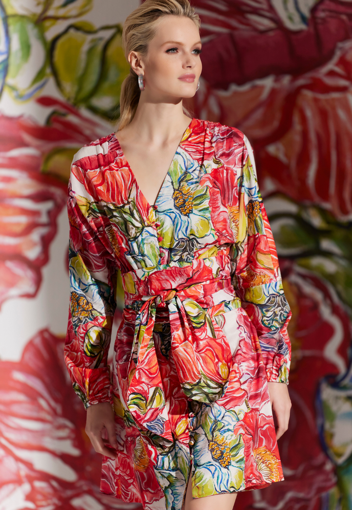 Woman wearing short cotton day dress in a red floral print by designer Ala von Auersperg for womens luxury travel clothing