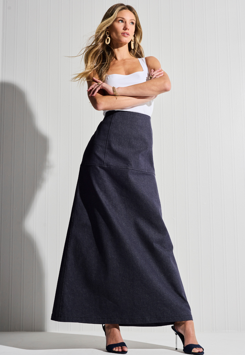 Woman wearing denim long skirt with white cotton tank top by designer Ala von Auersperg for womens luxury travel clothing