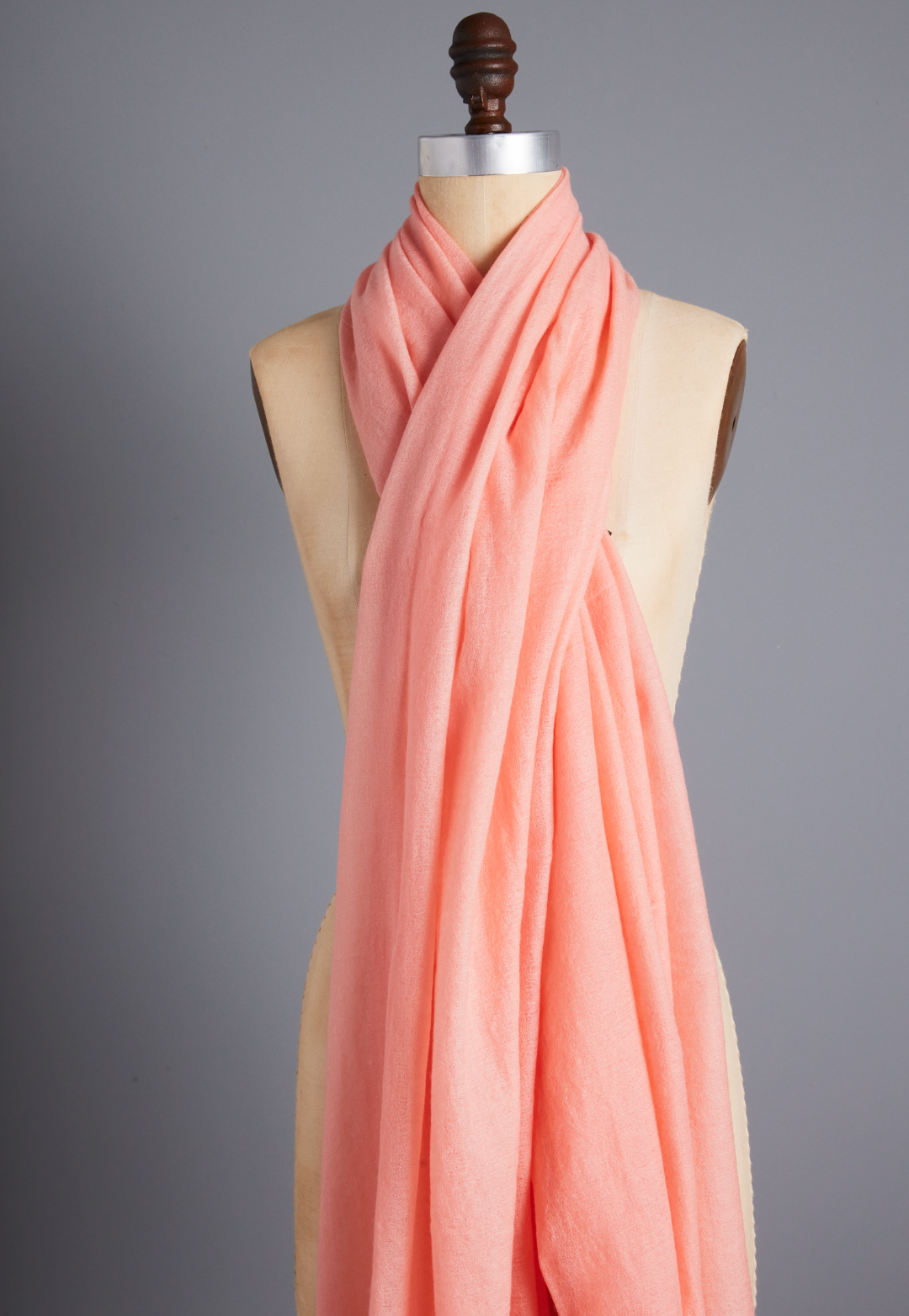 Apricot peach 100% cashmere wrap styled as a scarf on a dress form