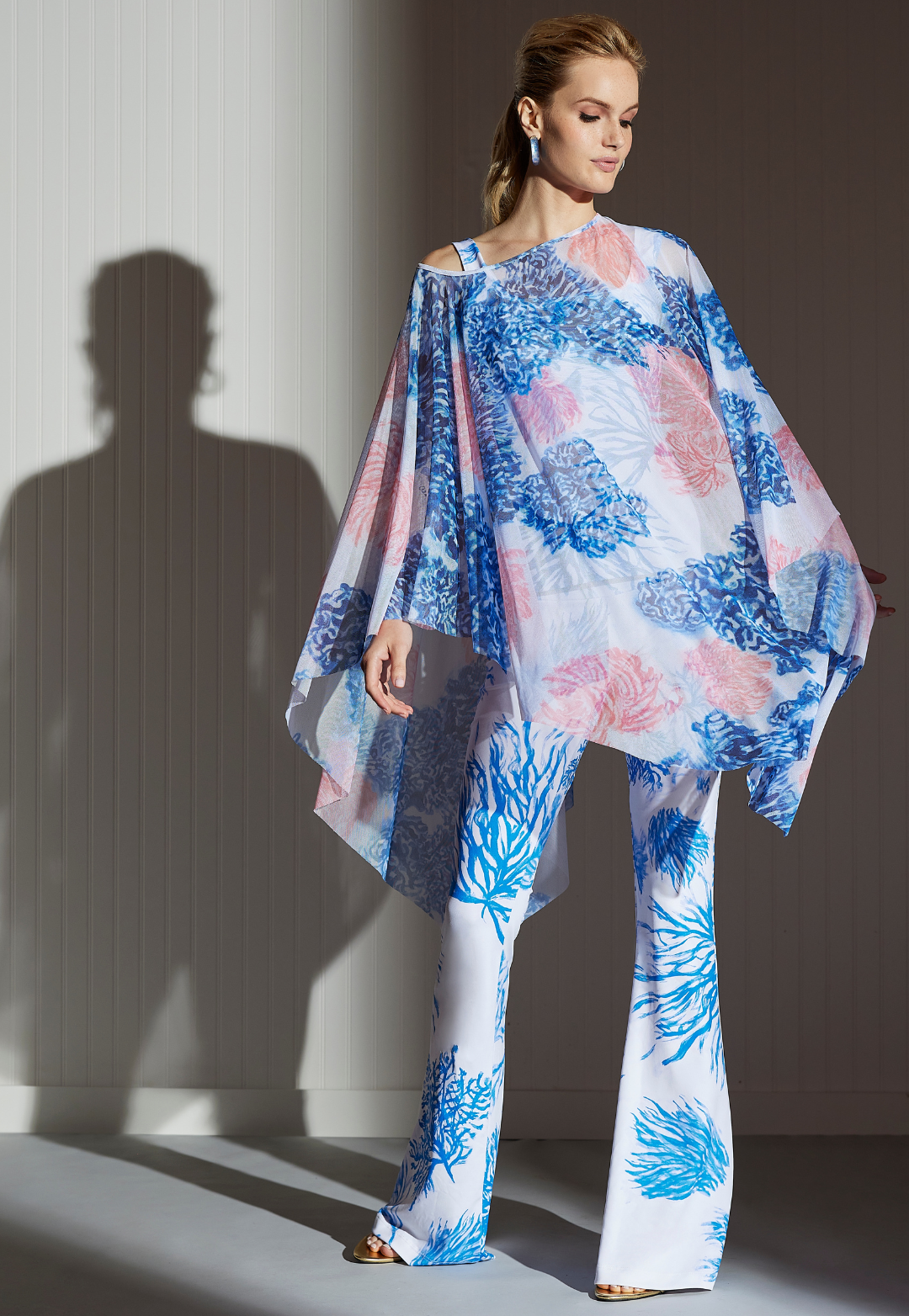 Woman wearing Artemisia blue and pink nautical coral sheer mesh poncho with coordinating printed pants