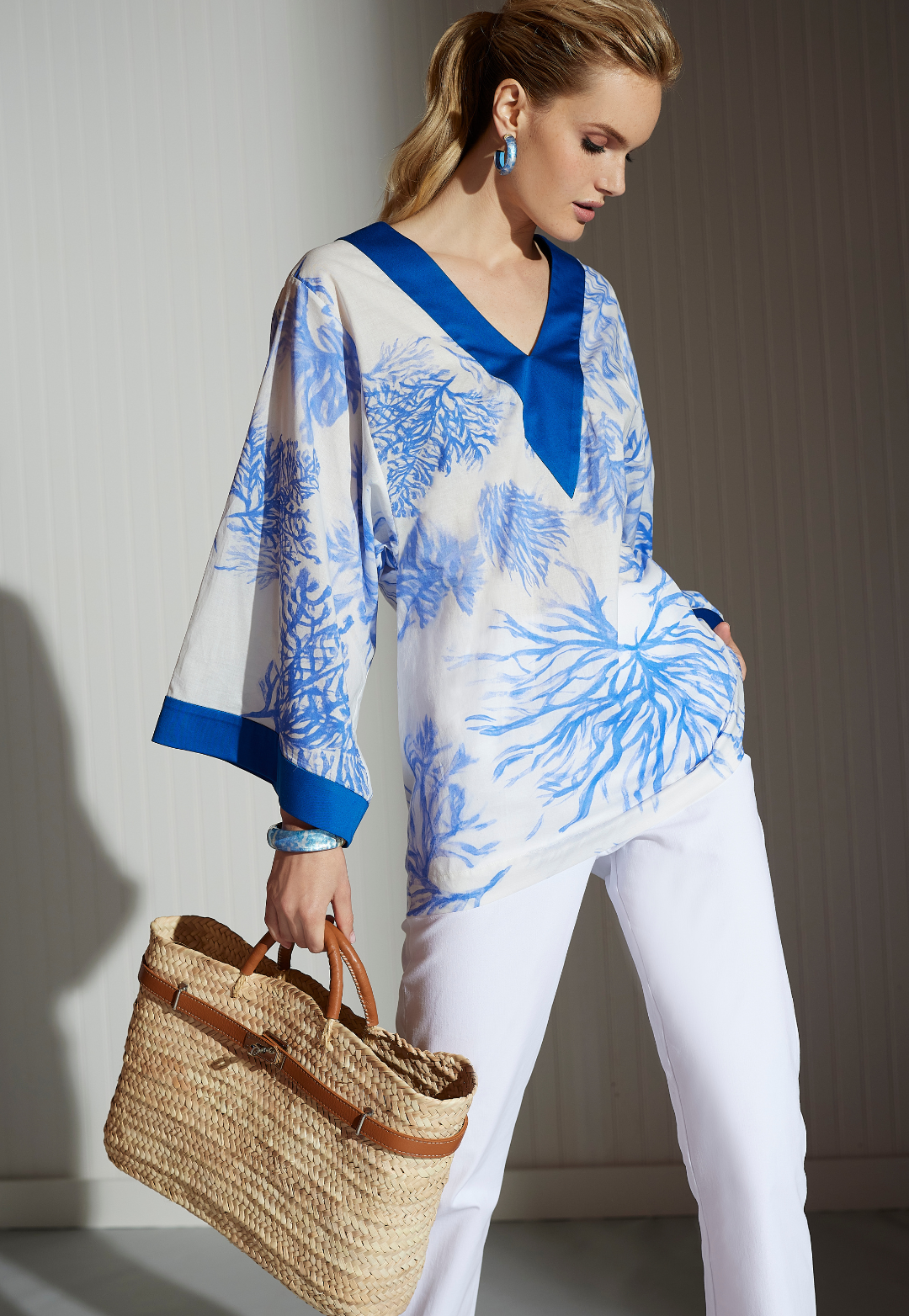 Woman wearing Gena blue and white nautical cotton tunic with blue silk trim and white pants