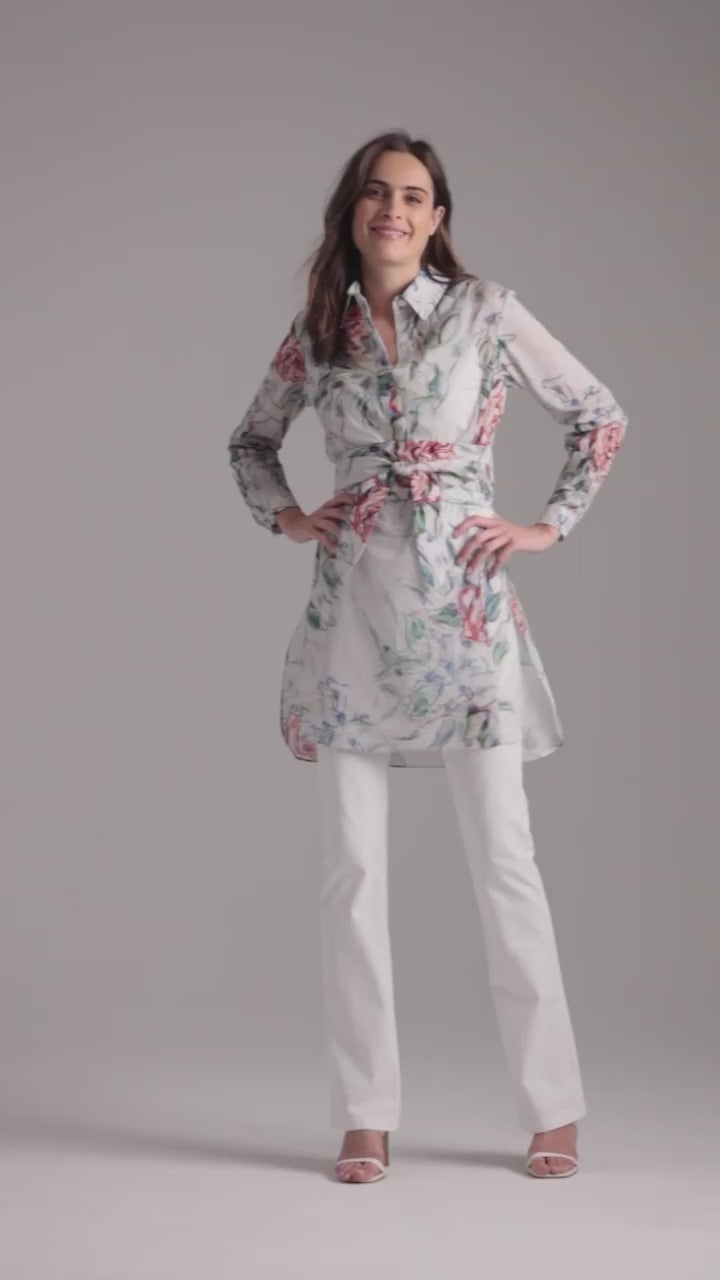 Woman wearing rose printed cotton tunic with belt and italian stretch cotton white pants by Ala von Auersperg