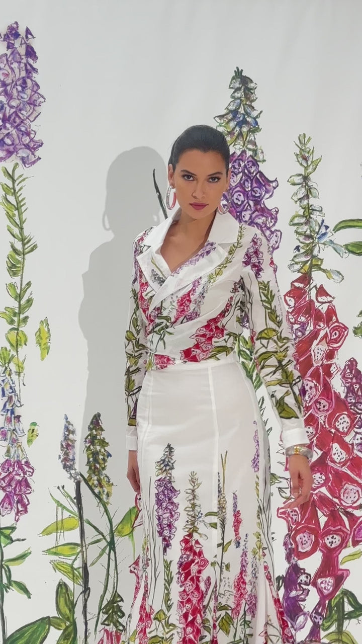 Video of a woman wearing a cotton wrap top and skirt in a matching white floral print by designer Ala von Auersperg for womens luxury travel clothing