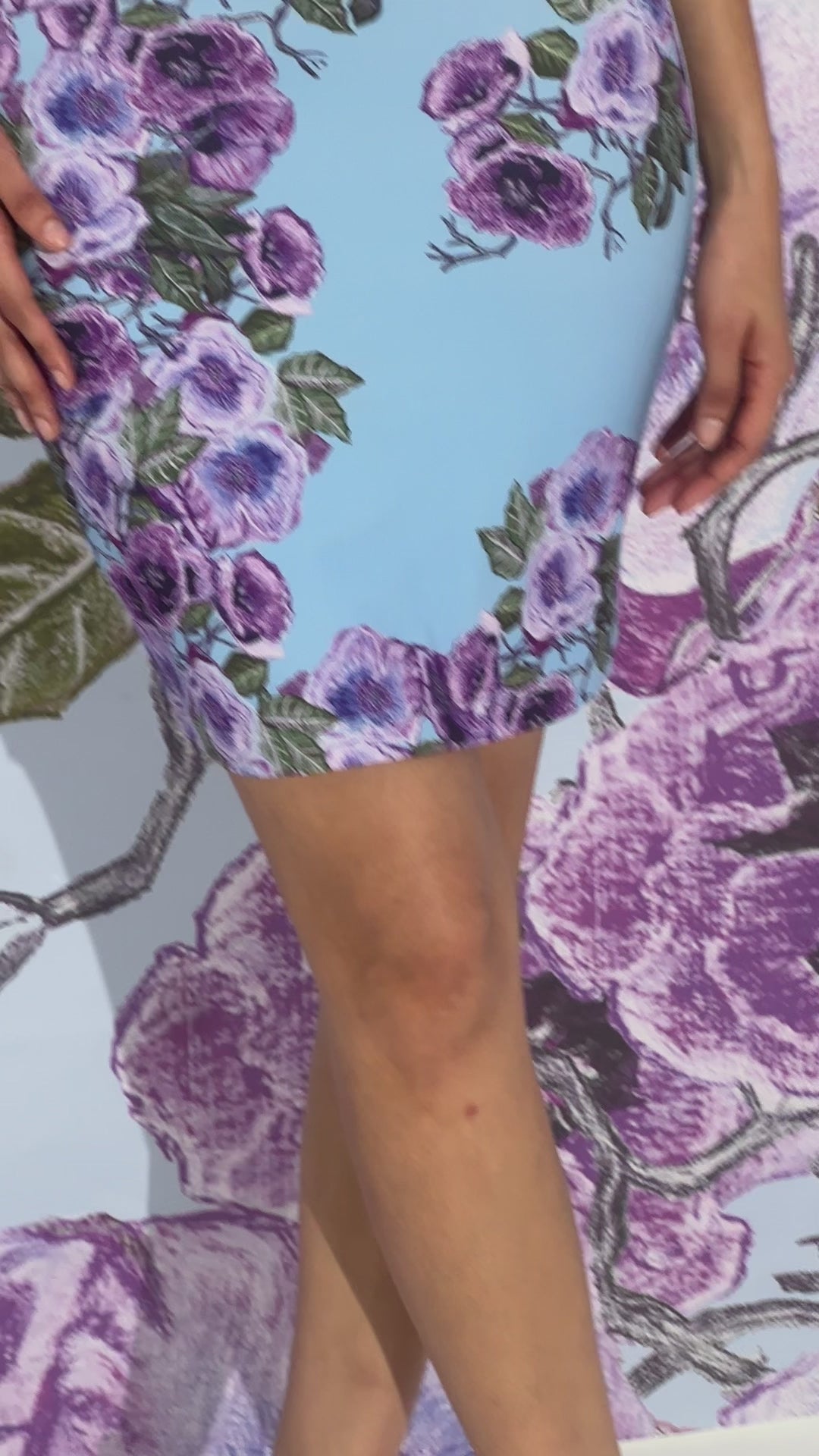 Video of a woman wearing a mini stretch knit dress in a purple floral print by designer Ala von Auersperg for womens luxury travel clothing