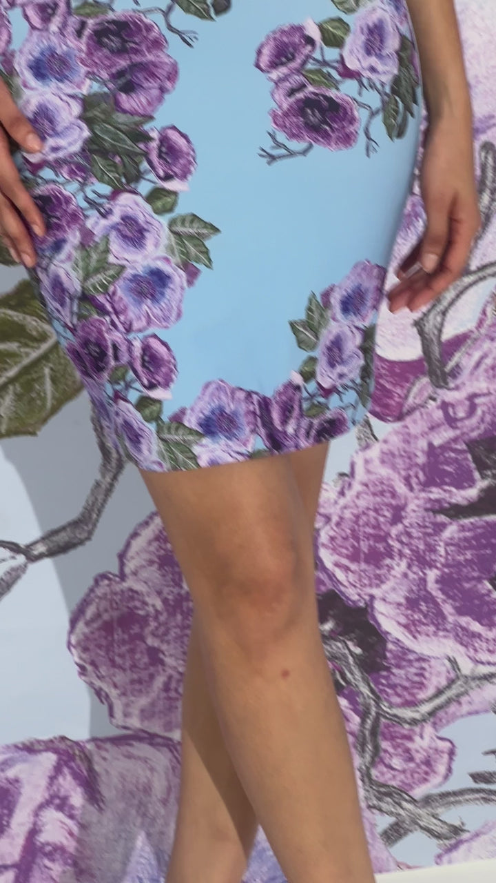 Video of a woman wearing a mini stretch knit dress in a purple floral print by designer Ala von Auersperg for womens luxury travel clothing