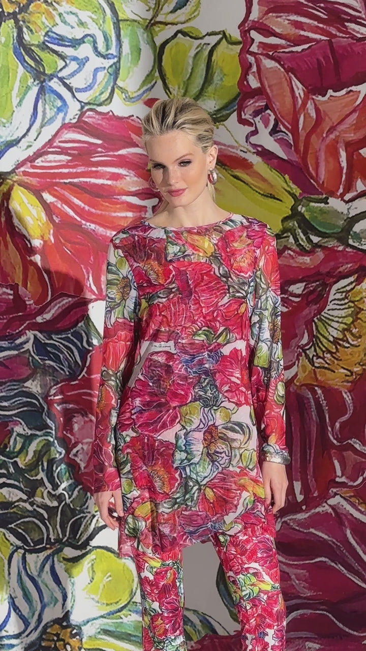 Video of a woman wearing a sheer mesh top over matching tank top and pants in a red floral print by designer Ala von Auersperg for womens luxury travel clothing