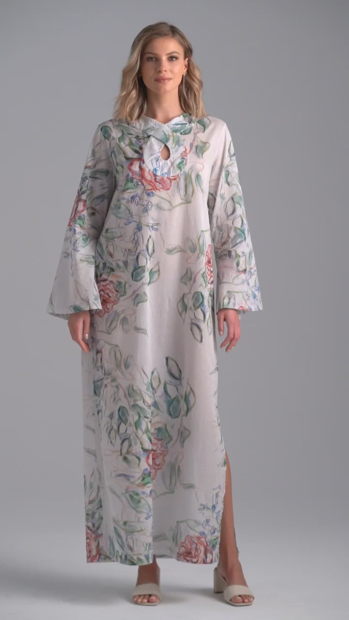 Woman wearing rose printed cotton bell sleeved long kaftan with figure 8 collar detailing by Ala von Auersperg for summer 2023