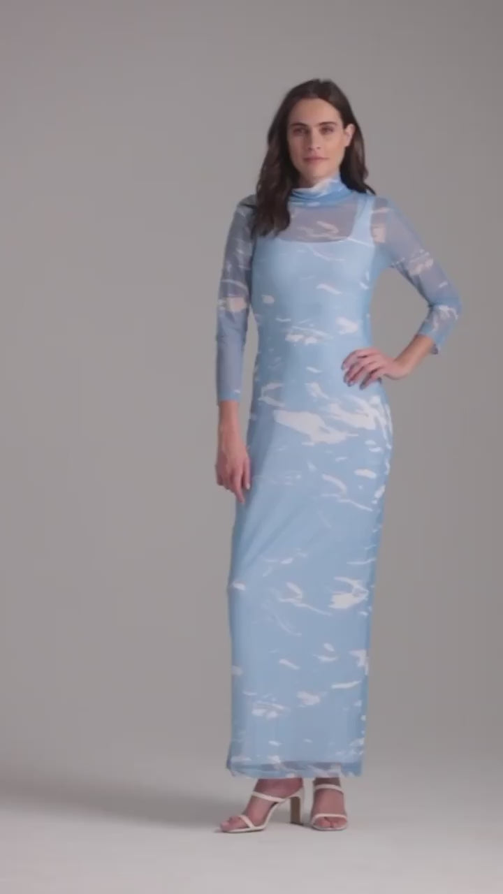 Woman wearing wave printed mesh turtlneck dress over white long stretch knit dress by Ala von Auersperg for summer 2023