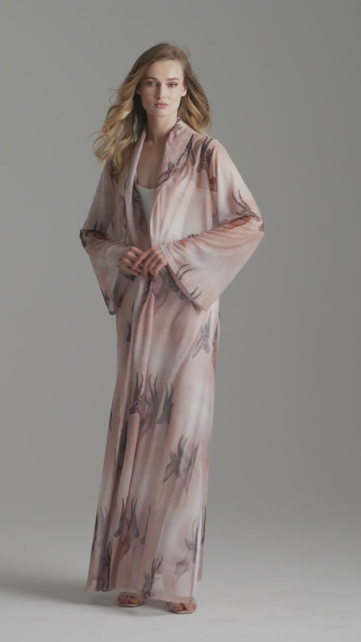 Woman wearing long mesh duster robe in brown deer print over white stretch knit tank top and pants by Ala von Auersperg for fall 2023