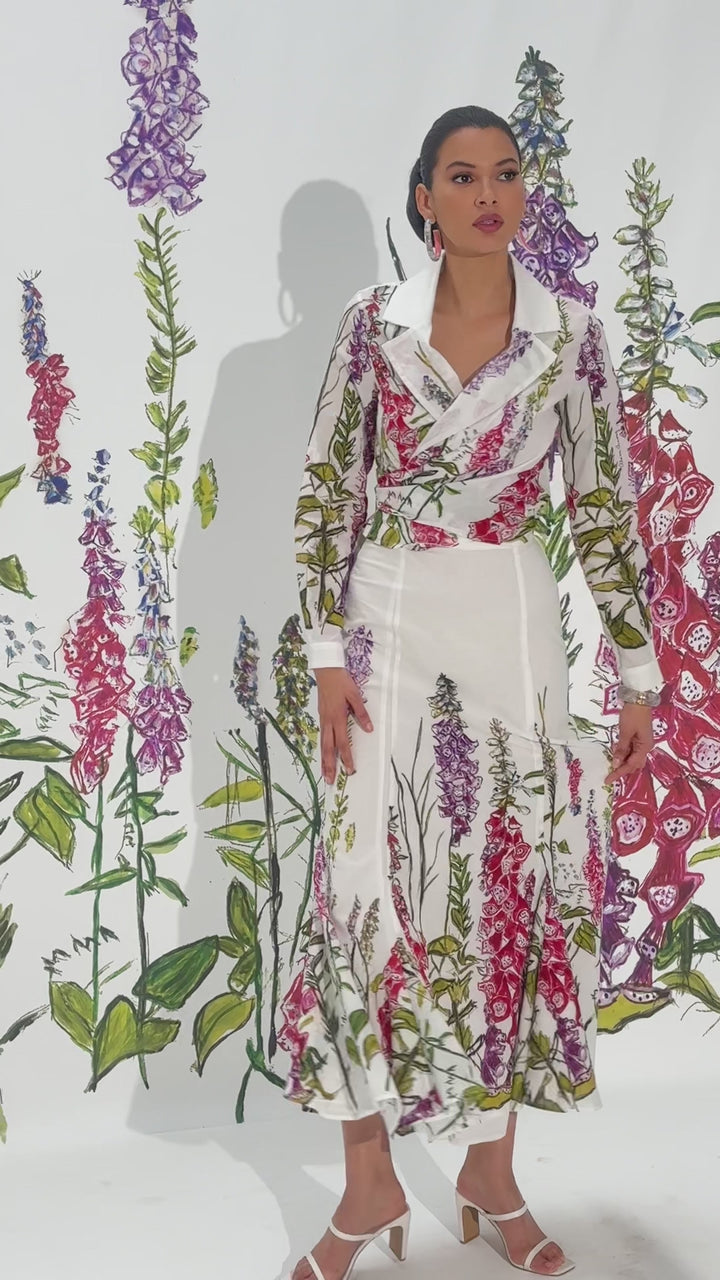 Video of a woman wearing a white cotton skirt with a wrap top in a matching floral print by designer Ala von Auersperg for womens luxury travel clothing