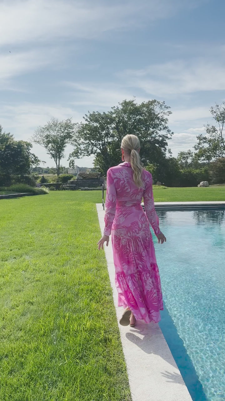 Video of a woman wearing a pink cotton shirt and skirt in a nautical pattern by the pool