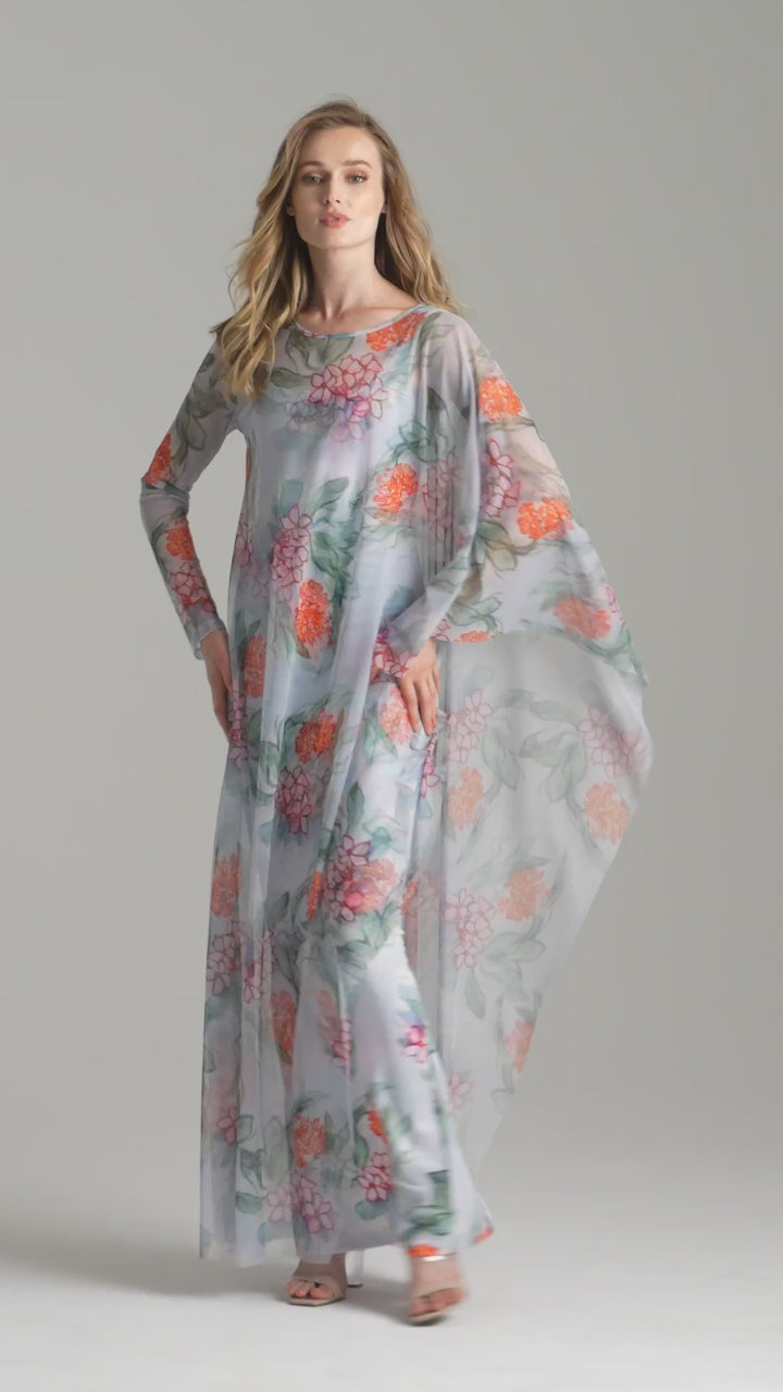 Video of woman spinning wearing mesh kaftan floral topper over long stretch knit floral dress by Ala von Auersperg