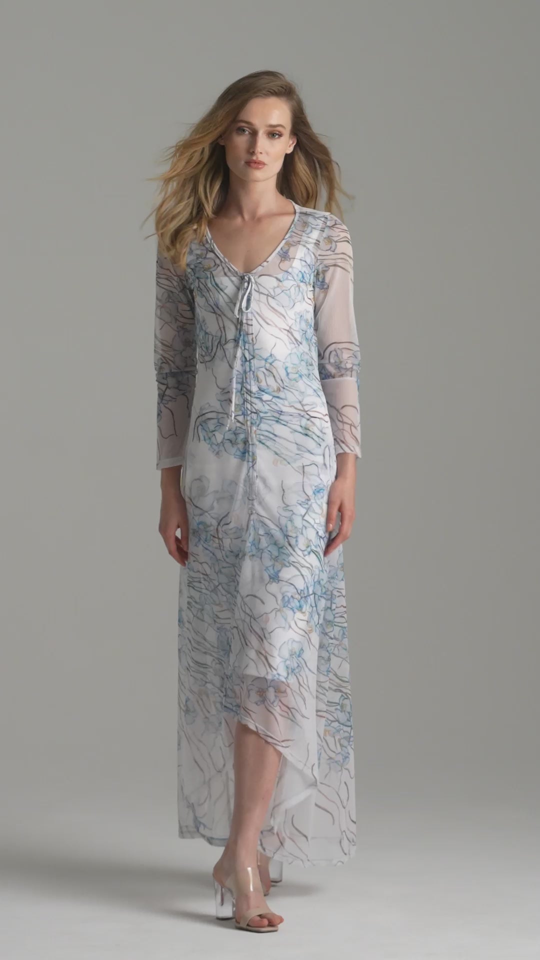 Video of a woman wearing a white blue orchid printed mesh bathing suit cover up over a white stretch knit short dress by Ala von Auersperg for spring 2024