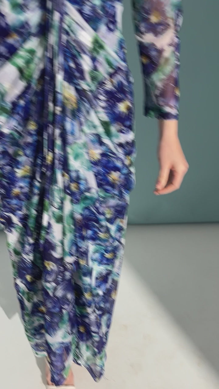 Video of a woman wearing a drawstring sheer mesh dress topper over a matching long stretch knit dress in a blue floral print and over a white long dress by designer Ala von Auersperg for womens luxury travel clothing