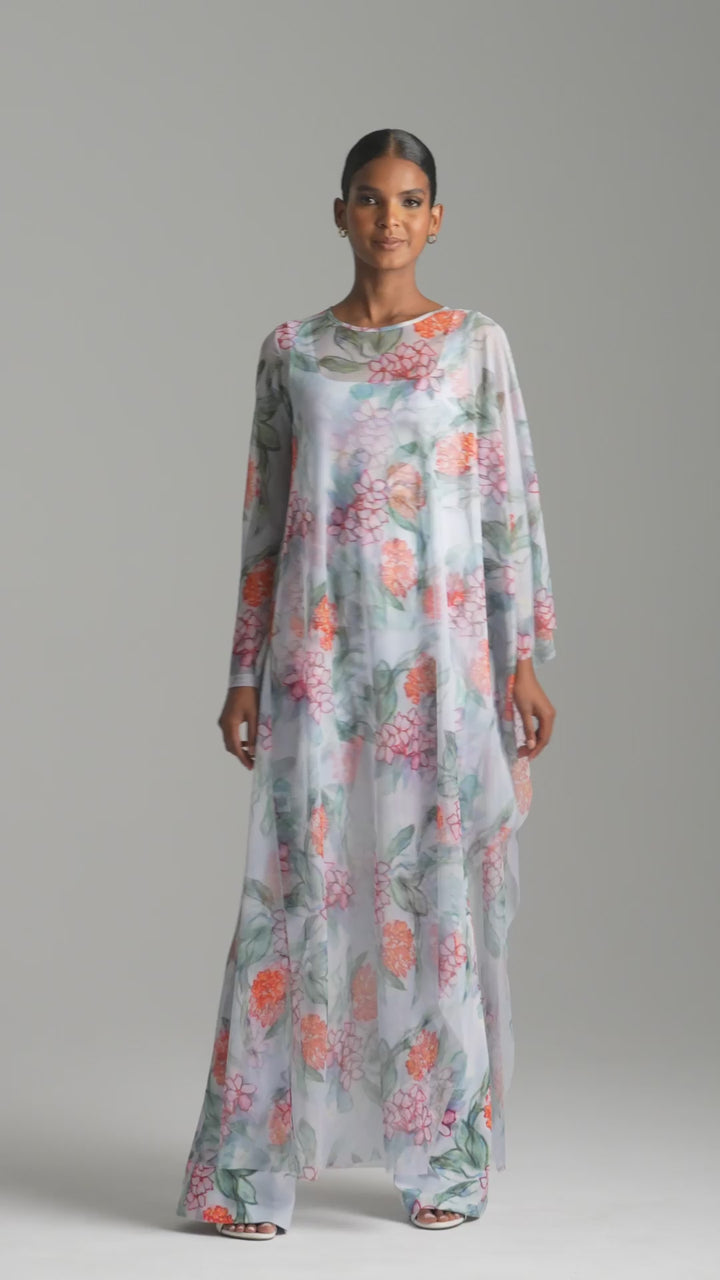 Woman wearing meh floral kaftan over stretch knit tank top and pants by Ala von Auersperg