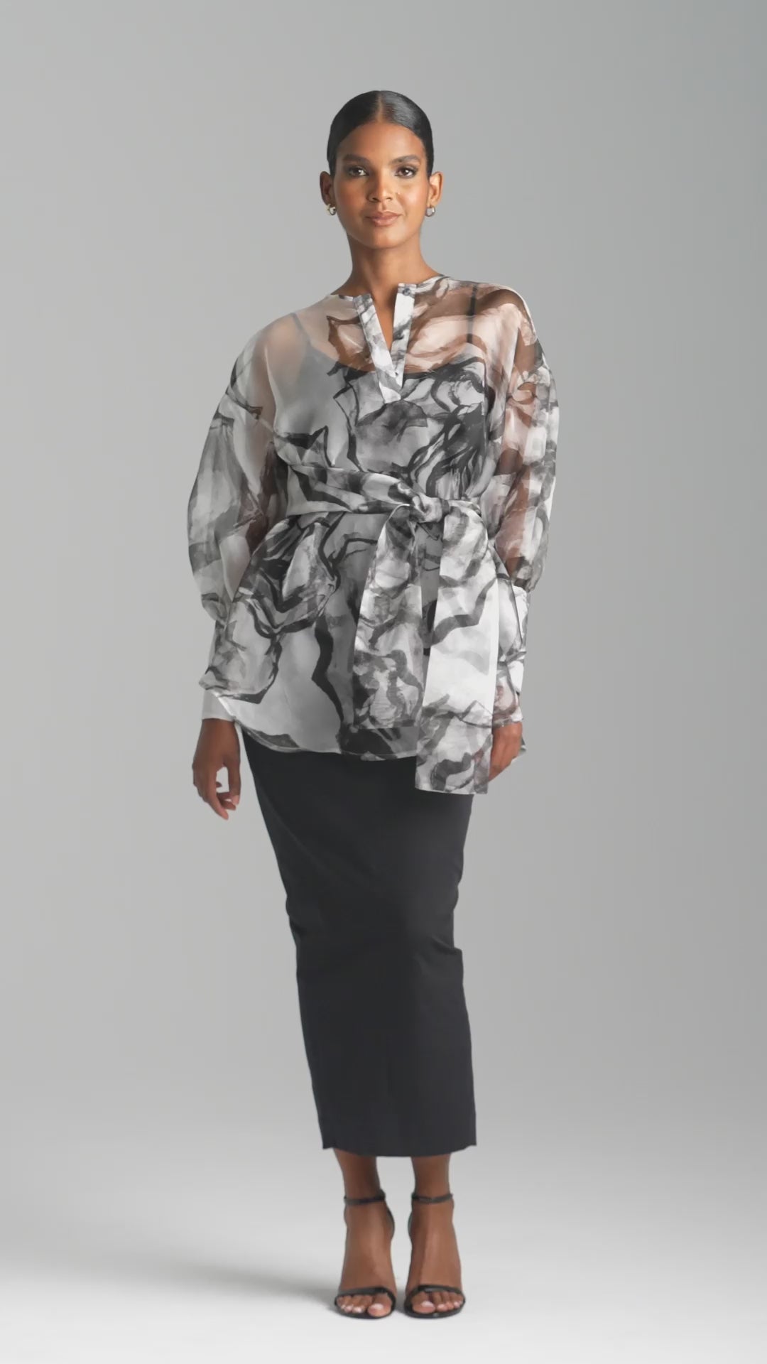 Woman wearing black rose printed silk organza balloon blouse with belt over black italian stretch cotton tank top and pencil skirt by Ala von Auersperg