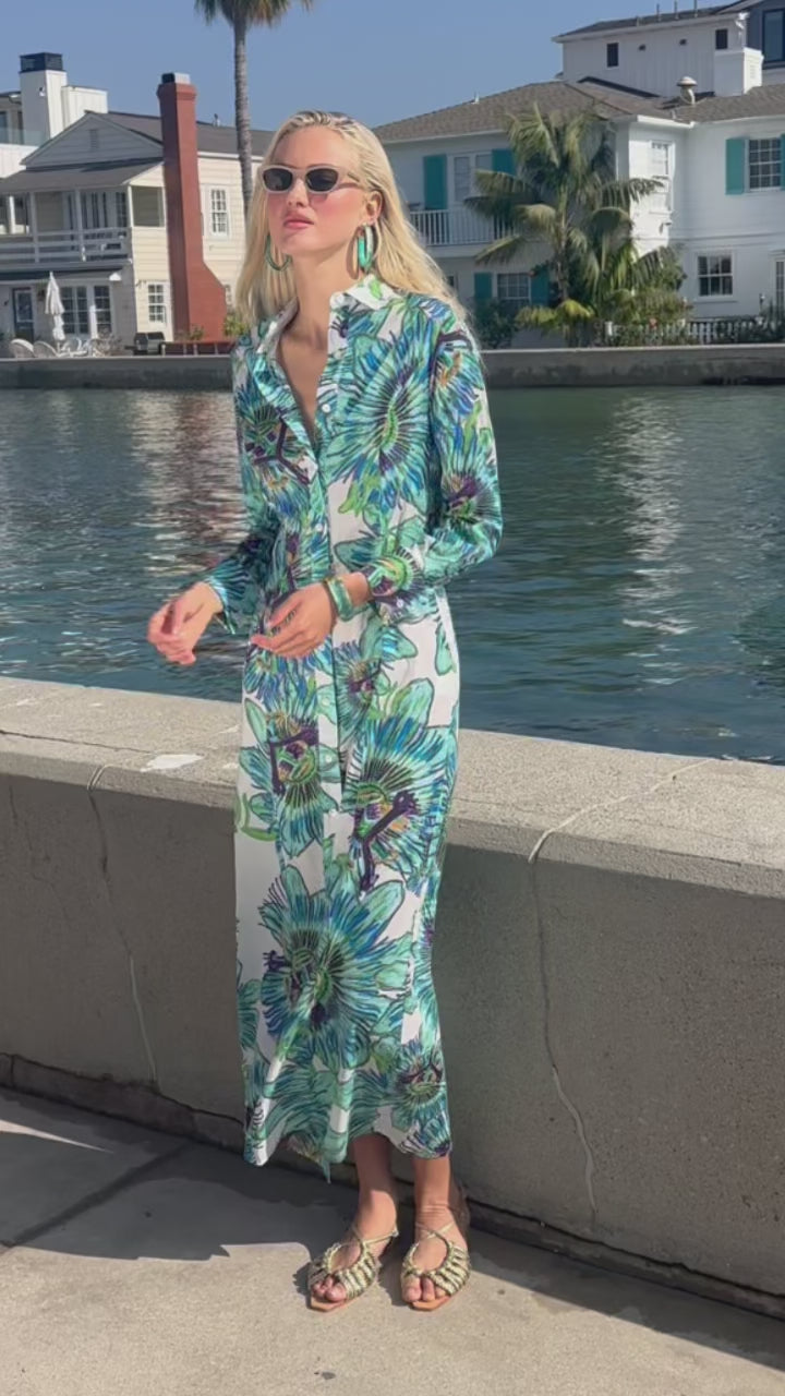 Video of a woman wearing a floral cotton shirt dress by the water