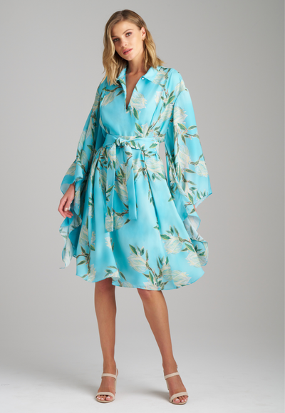 Woman wearing blue yucca printed silk short kimono style dress with belt by Ala von Auersperg for spring 2023