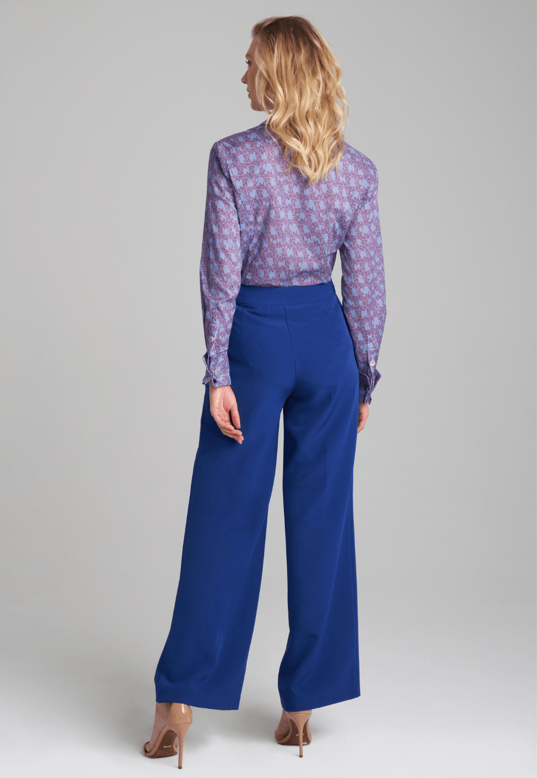 Woman wearing purple and blue bird printed cotton blouse and stretch knit blue pants by Ala von Auersperg for fall 2022 