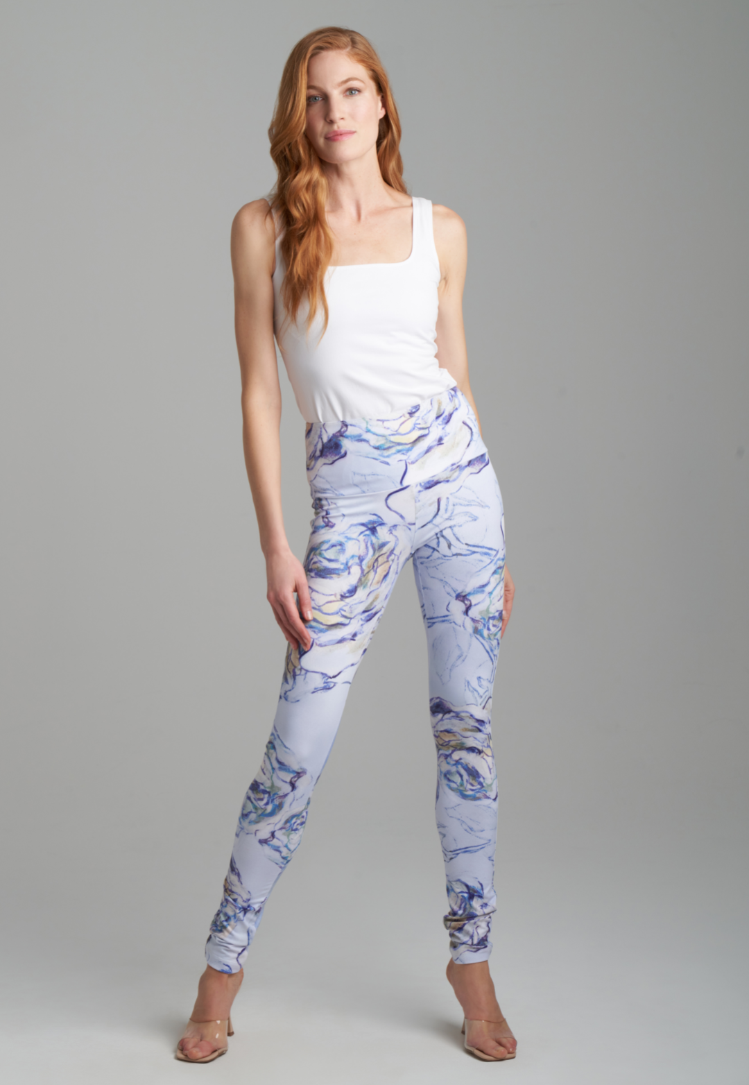Woman wearing blue rose printed skinny stretch knit pants with white italian stretch cotton tank topby Ala von Auersperg for spring summer 2022