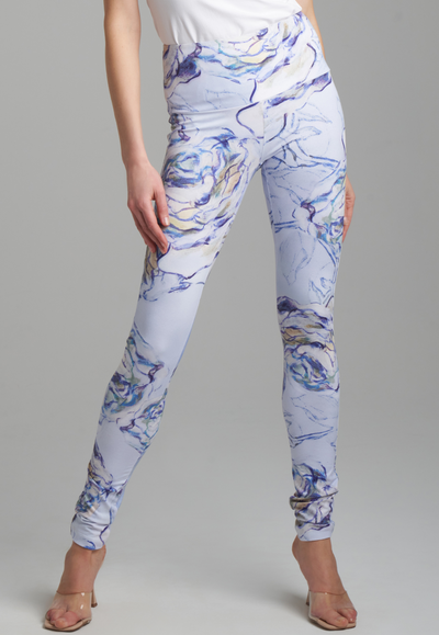 Woman wearing blue rose printed skinny stretch knit pants with white italian stretch cotton tank topby Ala von Auersperg for spring summer 2022