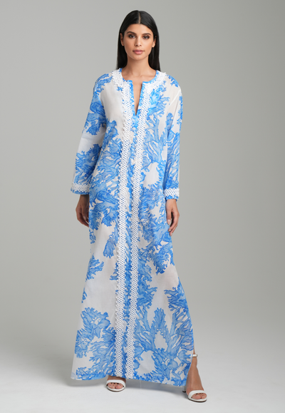 Woman wearing blue coral printed cotton voile kaftan with white trim by Ala von Auersperg for resort 2023