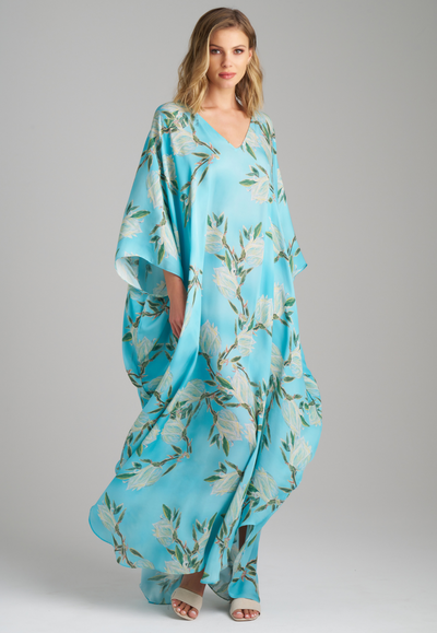 Woman wearing blue silk yucca printed long kaftan with v neck by Ala von Auersperg for spring 2023