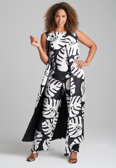 Woman wearing long silk palm leaf printed reversible long vest over silk palm leaf printed black and white shell tank top and wide leg silk pants by Ala von Auersperg for holiday 2022