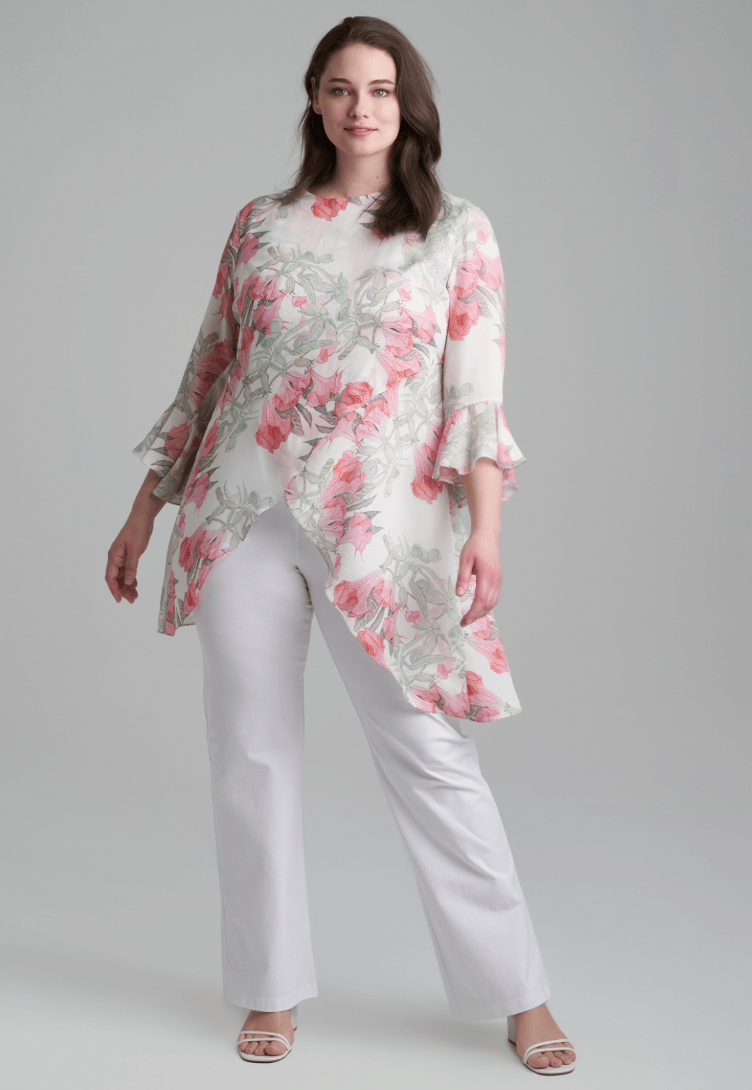Woman wearing silk asymmetrical flower printed blouse with stretch knit white pants by Ala von Auersperg for spring summer 2022