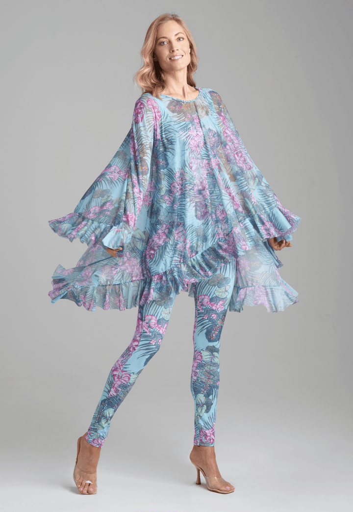 Woman wearing mesh printed orchid and palm poncho over stretch knit tank top and stretch knit pant printed in orchid and palm by Ala von Auersperg for resort 2022
