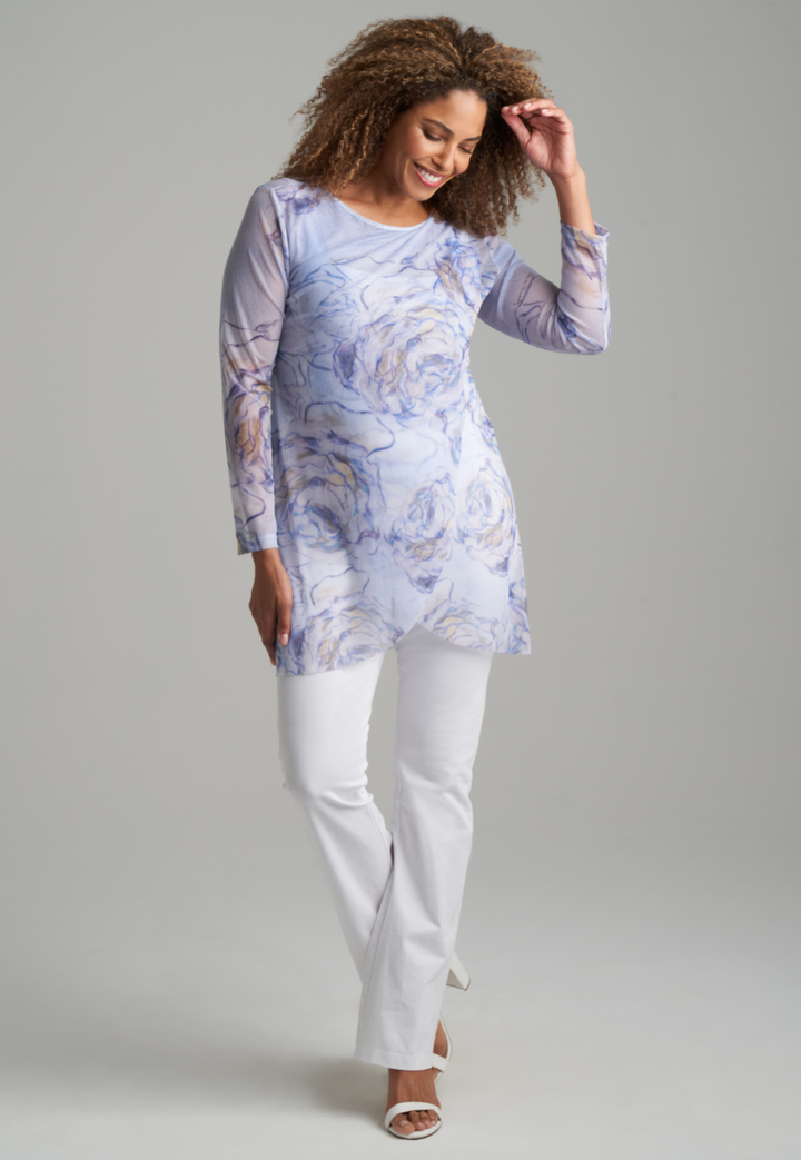 Woman wearing blue rose printed mesh tunic over white stretch knit tank top and pants by Ala von Auersperg for spring summer 2022