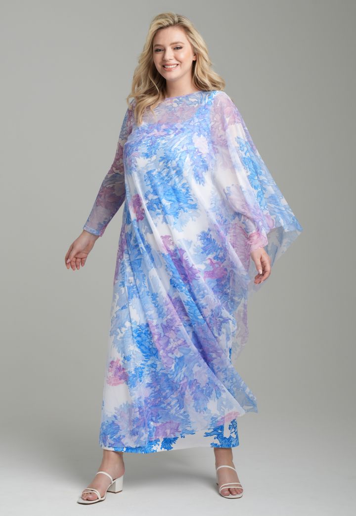 Woman wearing rainbow coral printed one armed mesh kaftan poncho over blue coral printed stretch knit long tank dress by Ala von Auersperg for resort 2023