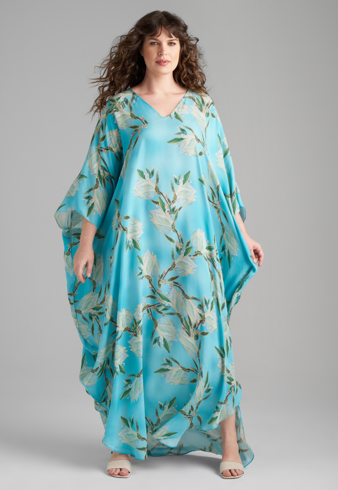 Woman wearing blue silk yucca printed long kaftan with v neck by Ala von Auersperg for spring 2023