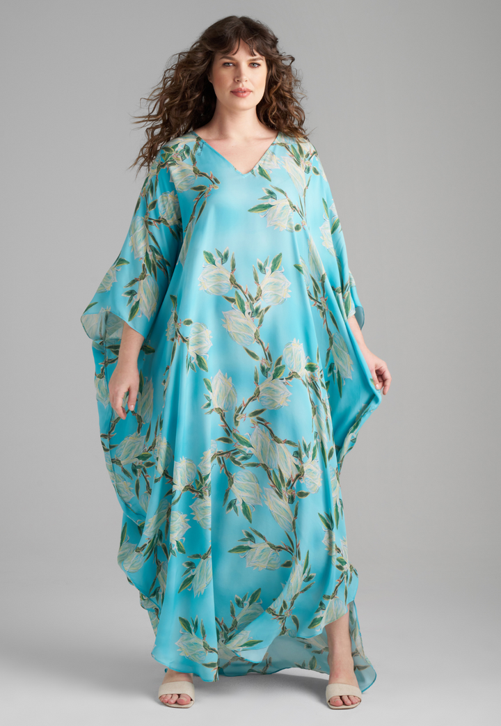 Woman wearing blue silk yucca printed long kaftan with v neck by Ala von Auersperg for spring 2023