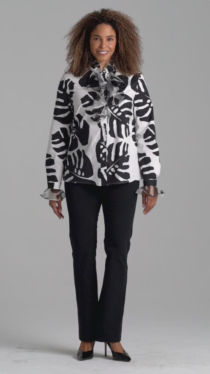 Woman wearing cotton turtleneck black and white palm leaf printed blouse with ruffle sleeve and collar details with italian stretch cotton pant in black by Ala von Auersperg for holiday 2022