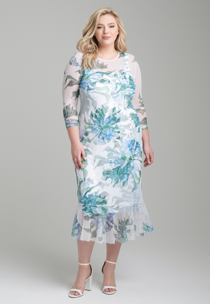 Woman wearing green mock coffee printed mesh dress with ruffle bottom over stretch knit mock coffee square necks short dress by Ala von Auersperg for resort 2023