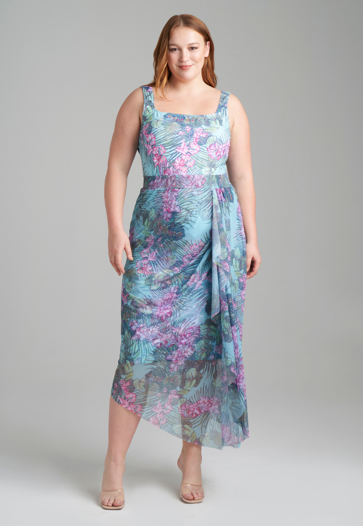 Woman wearing stretch knit tank top in green orchid and palm print with mesh printed orchid and palm green skirt by Ala von Auersperg for resort 2022