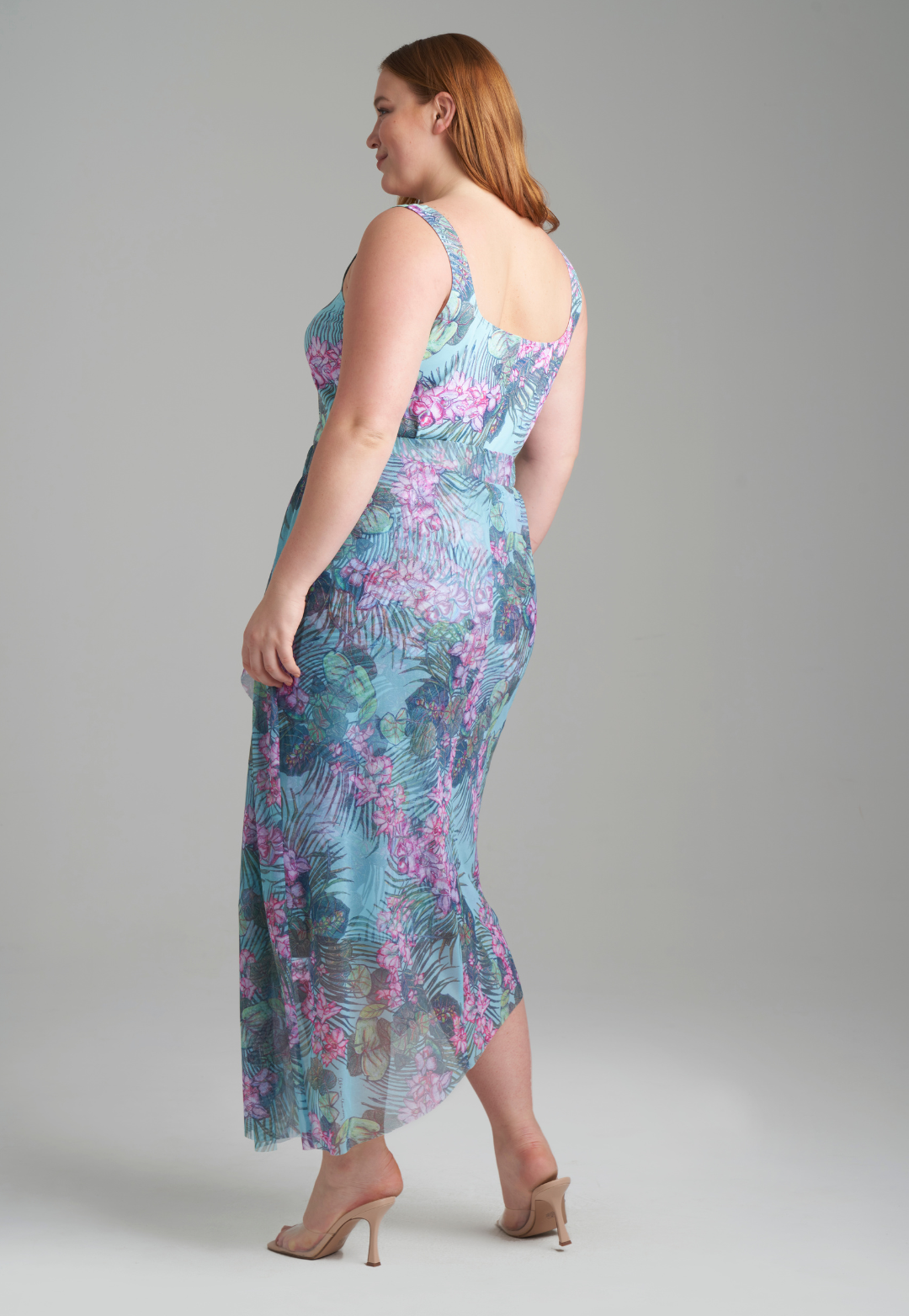 Woman wearing stretch knit tank top in green orchid and palm print with mesh printed orchid and palm green skirt by Ala von Auersperg for resort 2022