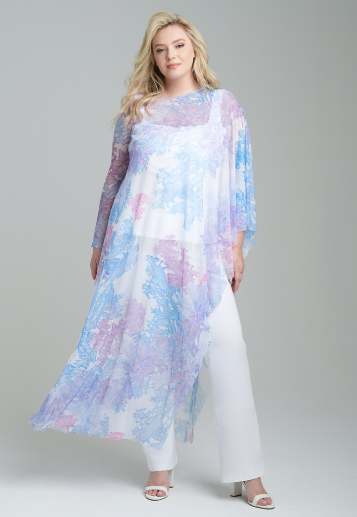 Woman wearing rainbow coral printed mesh one armed kaftan poncho over italian stretch cotton white tank top and pants by Ala von Auersperg for resort 2023