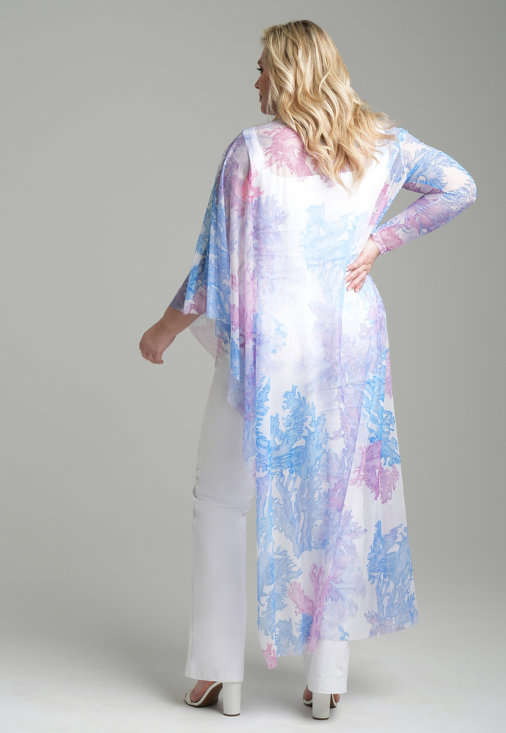 Woman wearing rainbow coral printed mesh one armed kaftan poncho over italian stretch cotton white tank top and pants by Ala von Auersperg for resort 2023