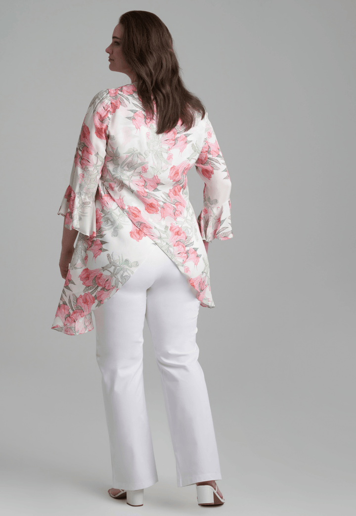 Woman wearing silk asymmetrical flower printed blouse with stretch knit white pants by Ala von Auersperg for spring summer 2022